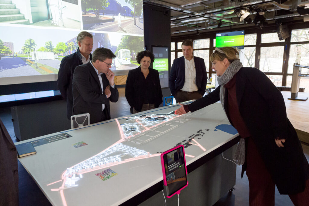 Gudrun Sack erläutert im Besucherzentrum der Tegel Projekt GmbH den Wandel des ehemaligen Flughafens Tegel zu einem Innovationspark für urbane Technologien: Berlin TXL – The Urban Tech Republic und einem smarten Wohnquartier: das Schumacher Quartier.